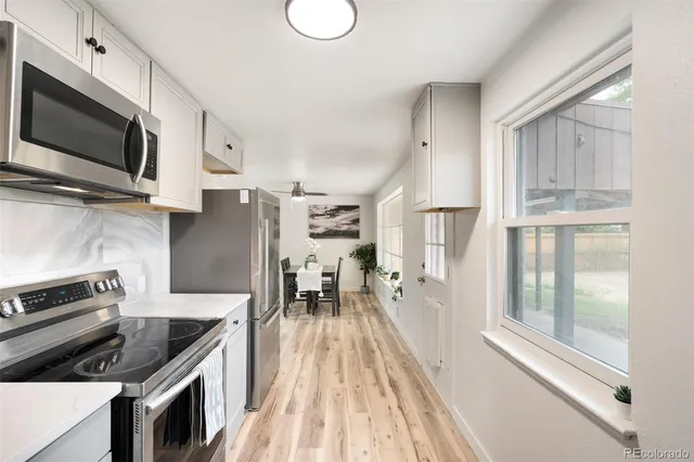 a kitchen with granite countertop a stove a sink and a microwave