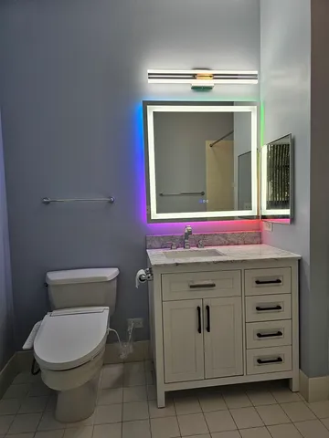 a bathroom with a toilet a sink and mirror