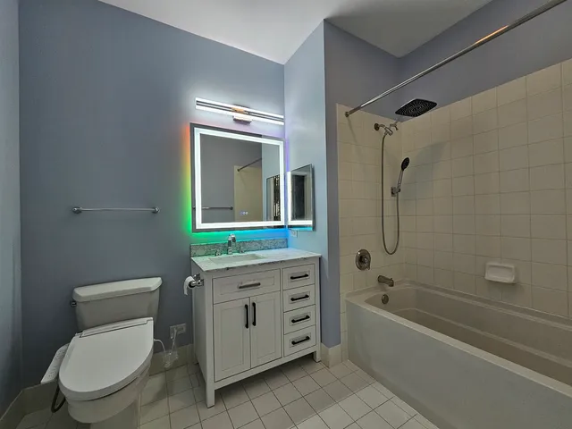 a bathroom with a granite countertop toilet a sink and bathtub