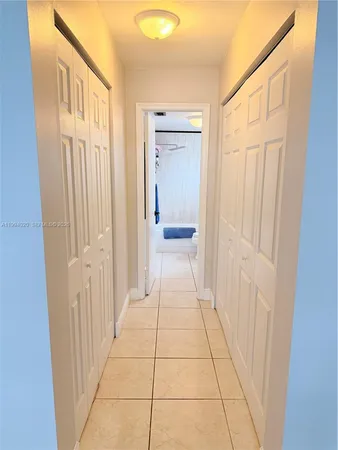 a hallway view with a wooden floor and a bathroom space