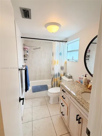a bathroom with a granite countertop sink a toilet and a mirror
