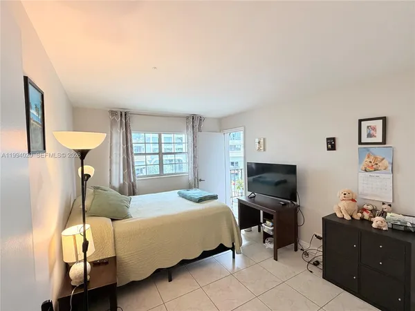 a bedroom with a bed and flat tv screen
