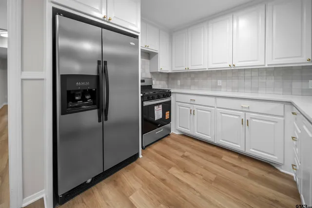 a kitchen with stainless steel appliances granite countertop a refrigerator and a stove