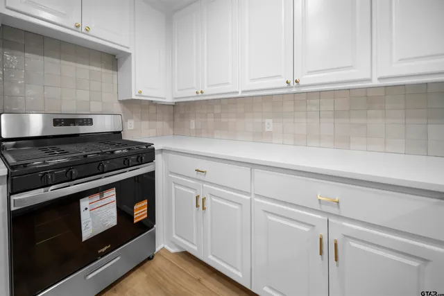 a kitchen with white cabinets and appliances