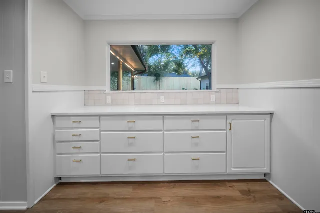 a view of white cabinets with a large window