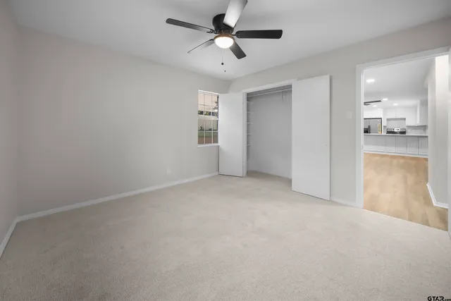 an empty room with a window and a fan