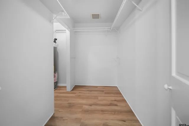 an empty room with wooden floor and a ceiling fan