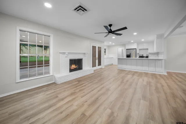 a view of an empty room with a fireplace and a window