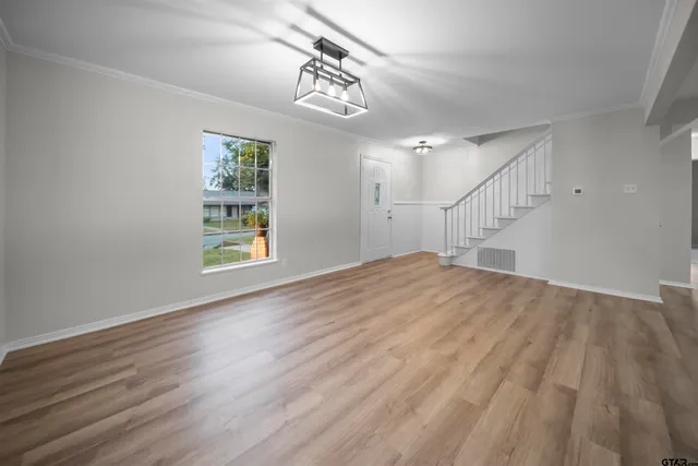 a view of empty room with wooden floor