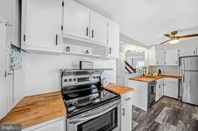 a kitchen with stainless steel appliances a stove and white cabinets