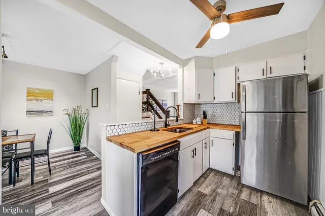 a kitchen with white cabinets and refrigerator