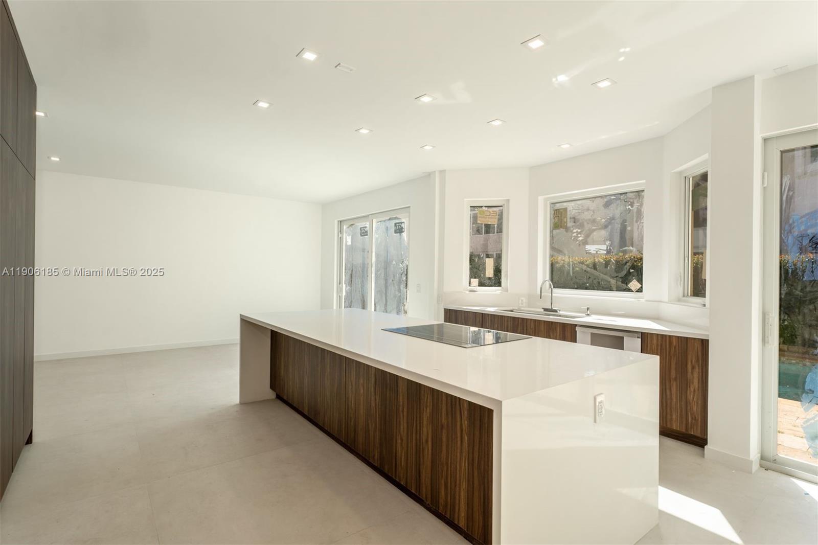 3944 194th Trail Sunny Isles Beach, FL 33160 - Photo 2 of 20 a living room with stainless steel appliances kitchen island a large counter top a sink and a refrigerator