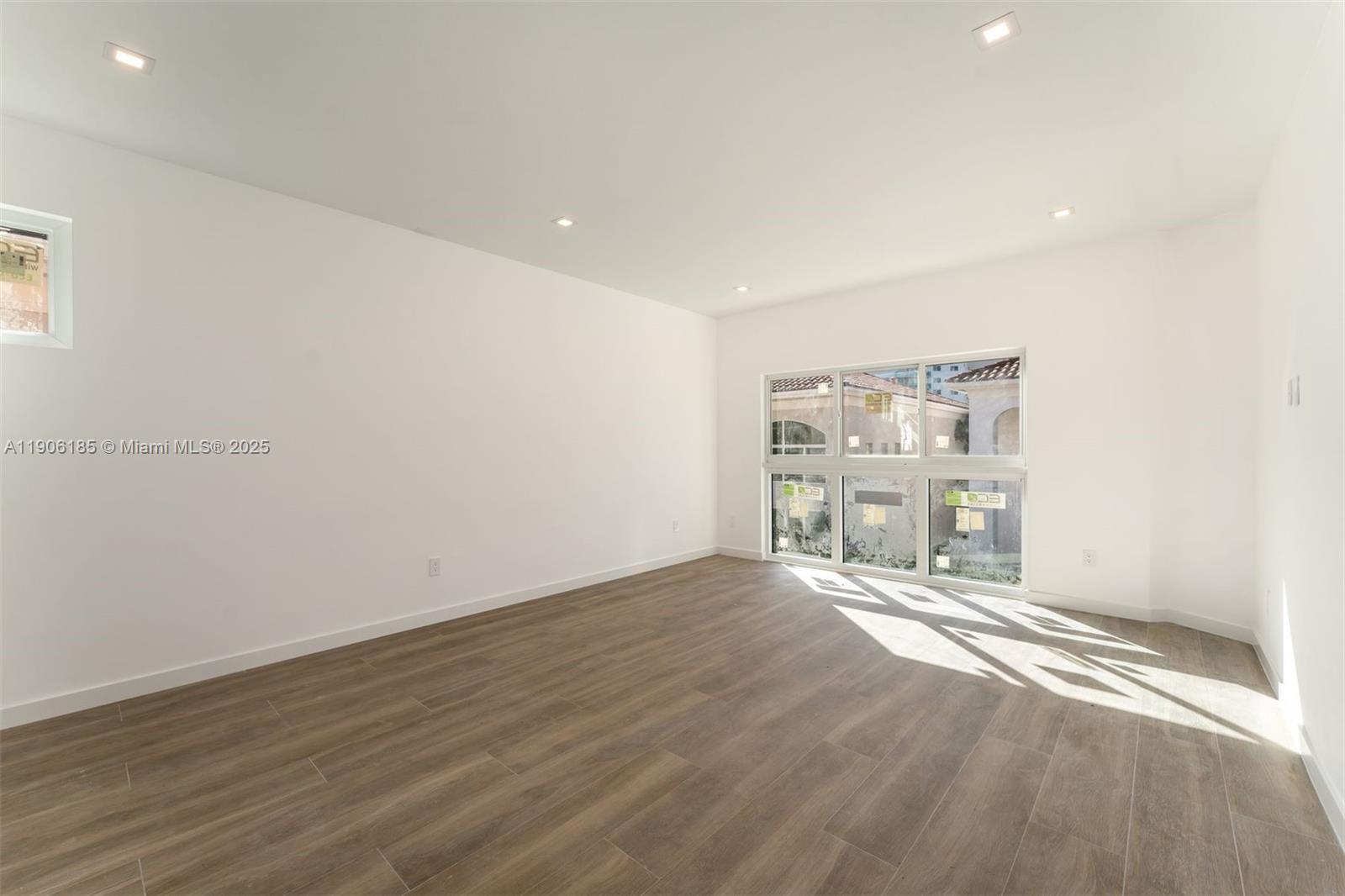 3944 194th Trail Sunny Isles Beach, FL 33160 - Photo 6 of 20 an empty room with wooden floor and windows