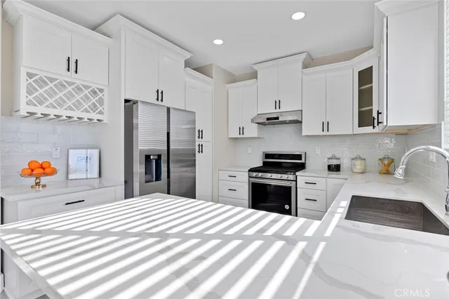 a kitchen with a refrigerator and white cabinets