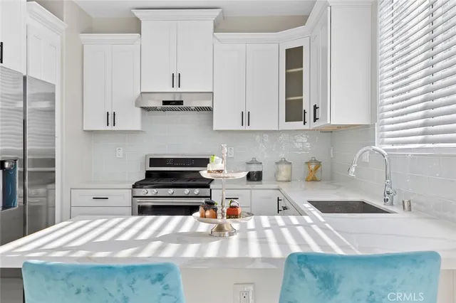 a kitchen with cabinets appliances a sink and a window