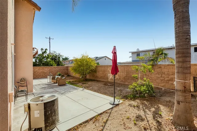 a view of a patio with couple of chairs and potted plants