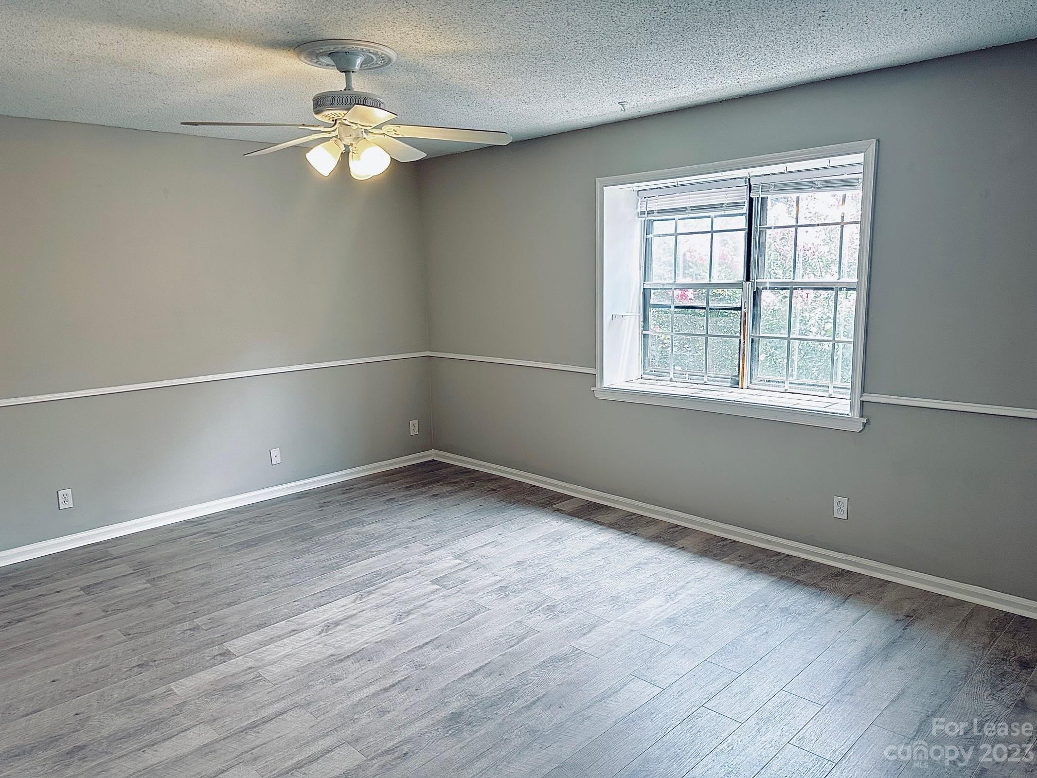 5805 Hunting Ridge Lane Charlotte, NC 28212 - Photo 2 of 7 an empty room with wooden floor and windows