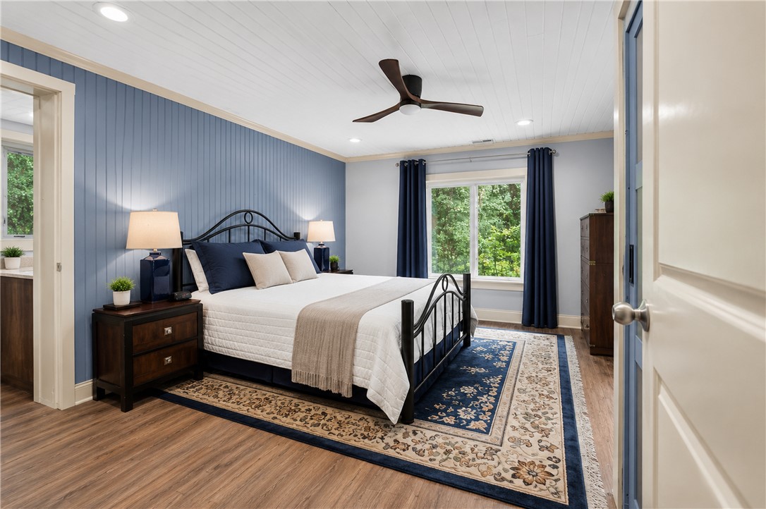 203 Muller Road Walhalla, SC 29691 - Photo 10 of 34 Warm LVP flooring and detailed beadboard wall accents elevate this tranquil bedroom retreat.