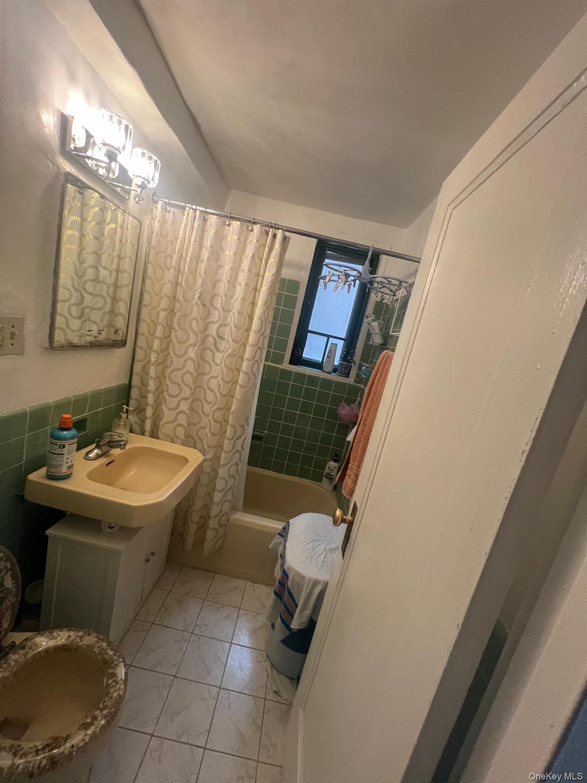 1450 Parkchester Road, Unit 3H Bronx, NY 10462 - Photo 4 of 8 Bathroom with shower / bath combo with shower curtain, vanity, and tile walls