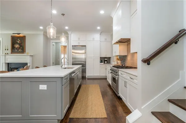 a kitchen with stainless steel appliances kitchen island granite countertop a stove a sink and a refrigerator