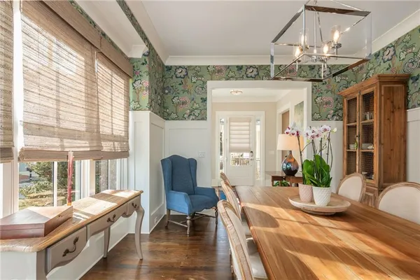 a large white kitchen with lots of counter space a sink appliances and dining table