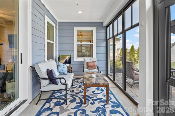 a dining room with furniture and a floor to ceiling window