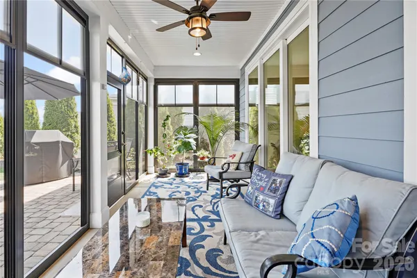 a living room with furniture and floor to ceiling windows