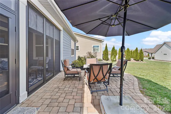 a view of a patio with a table and chairs under an umbrella