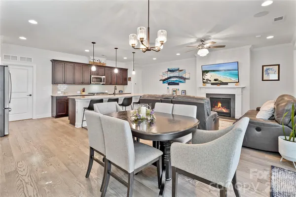 a view of a dining room with furniture a chandelier and wooden floor