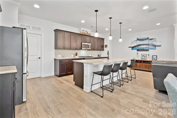 a kitchen with stainless steel appliances kitchen island granite countertop a sink and cabinets