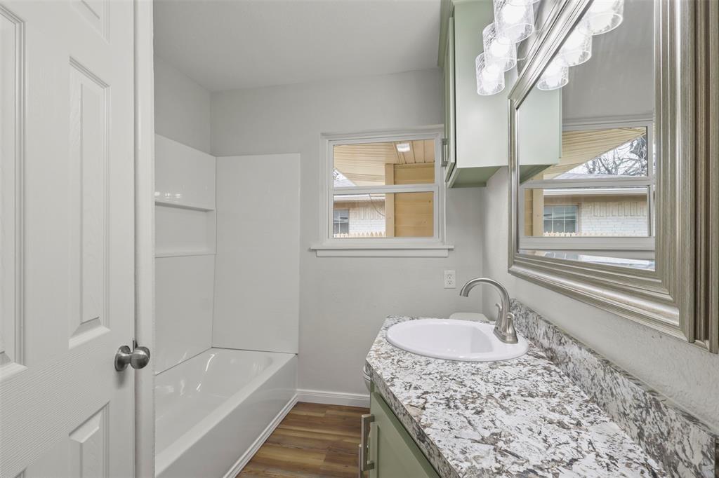 732 Bullock Street Denison, TX 75020 - Photo 15 of 29 a bathroom with a granite countertop sink and mirror with bathtub