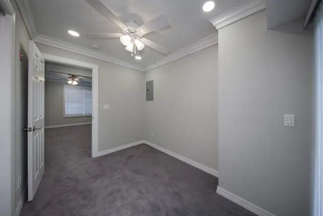an empty room with a chandelier fan and windows