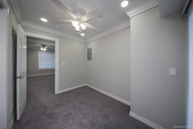 an empty room with a chandelier fan and windows