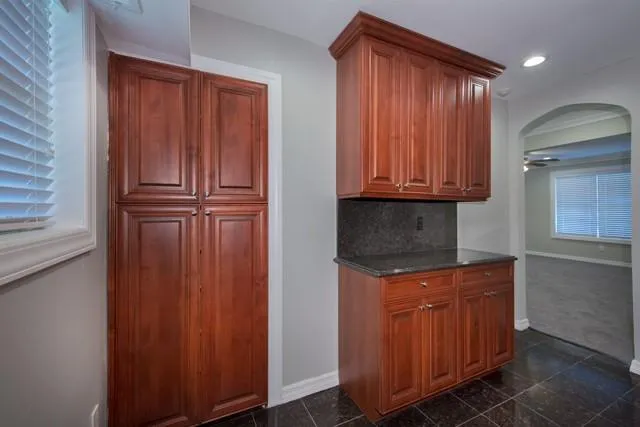 a kitchen with granite countertop wooden cabinets and a wooden floor