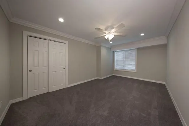 an empty room with a ceiling fan and a window