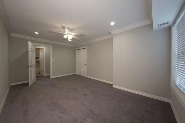 an empty room with a ceiling fan and a window