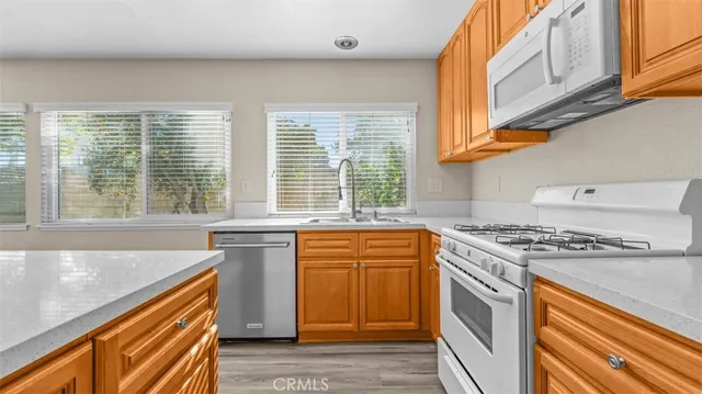 a kitchen with stainless steel appliances granite countertop a stove a sink and a microwave