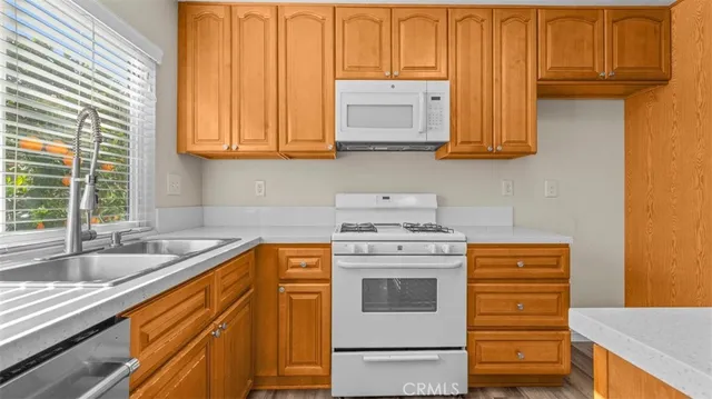 a kitchen with stainless steel appliances granite countertop a sink a stove and cabinets