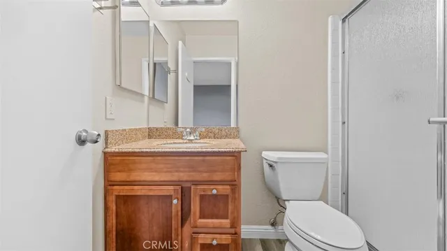a bathroom with a granite countertop toilet sink and mirror