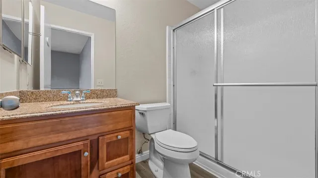 a bathroom with a granite countertop sink toilet and shower