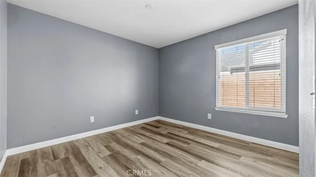 a view of a room with wooden floor and a window