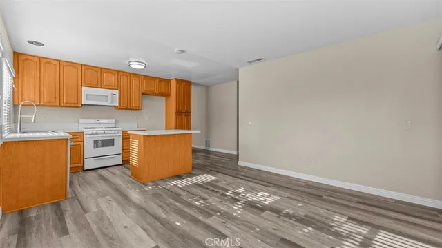 a kitchen with wooden floors and wooden cabinets