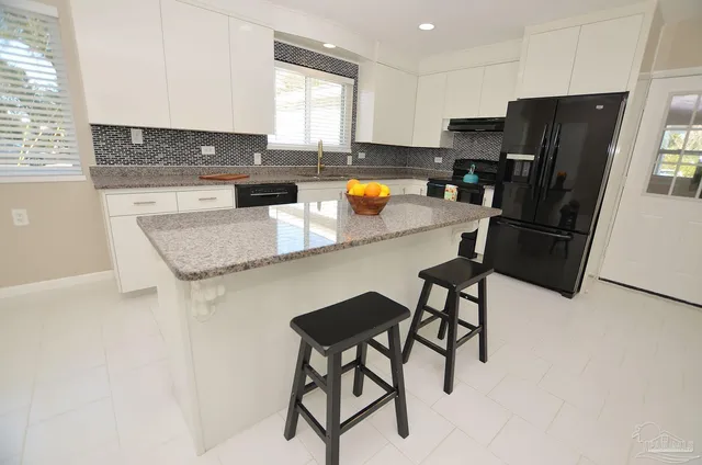 a kitchen with stainless steel appliances granite countertop a sink and a refrigerator