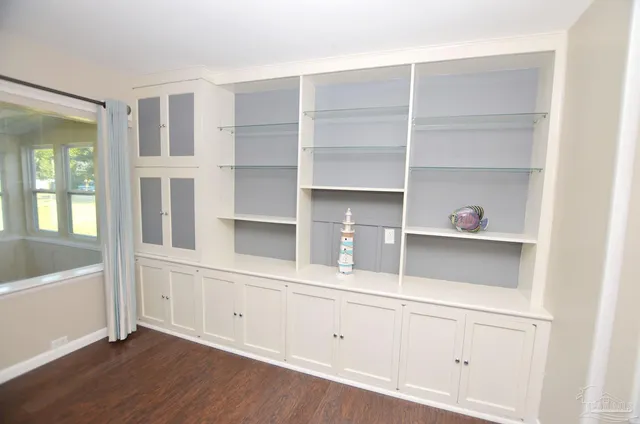 a view of an empty room with wooden floor