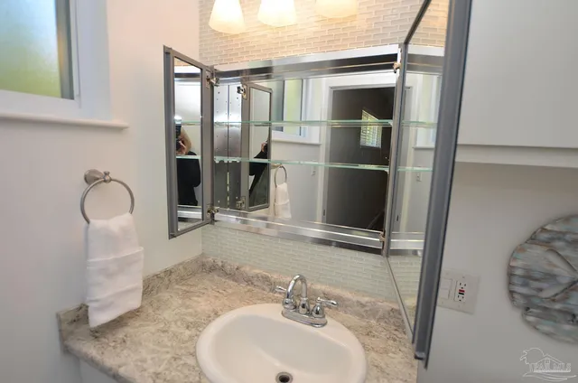 a bathroom with a sink vanity mirror and toilet