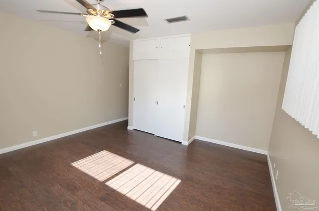 a front view of house with yard and trees in the background