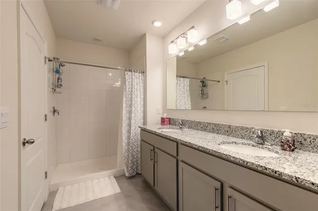 a bathroom with a granite countertop shower and a sink