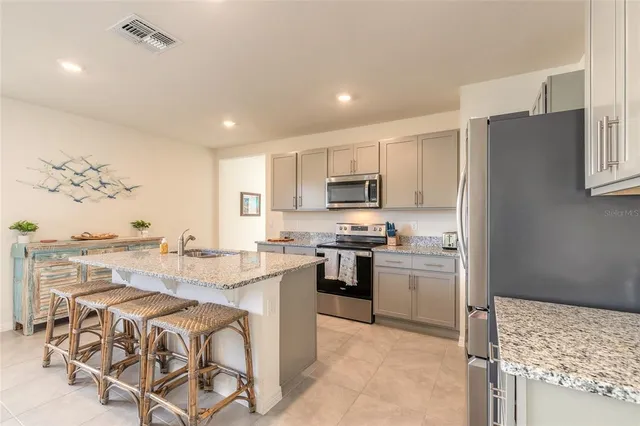 a kitchen with a stove a refrigerator and a stove top oven