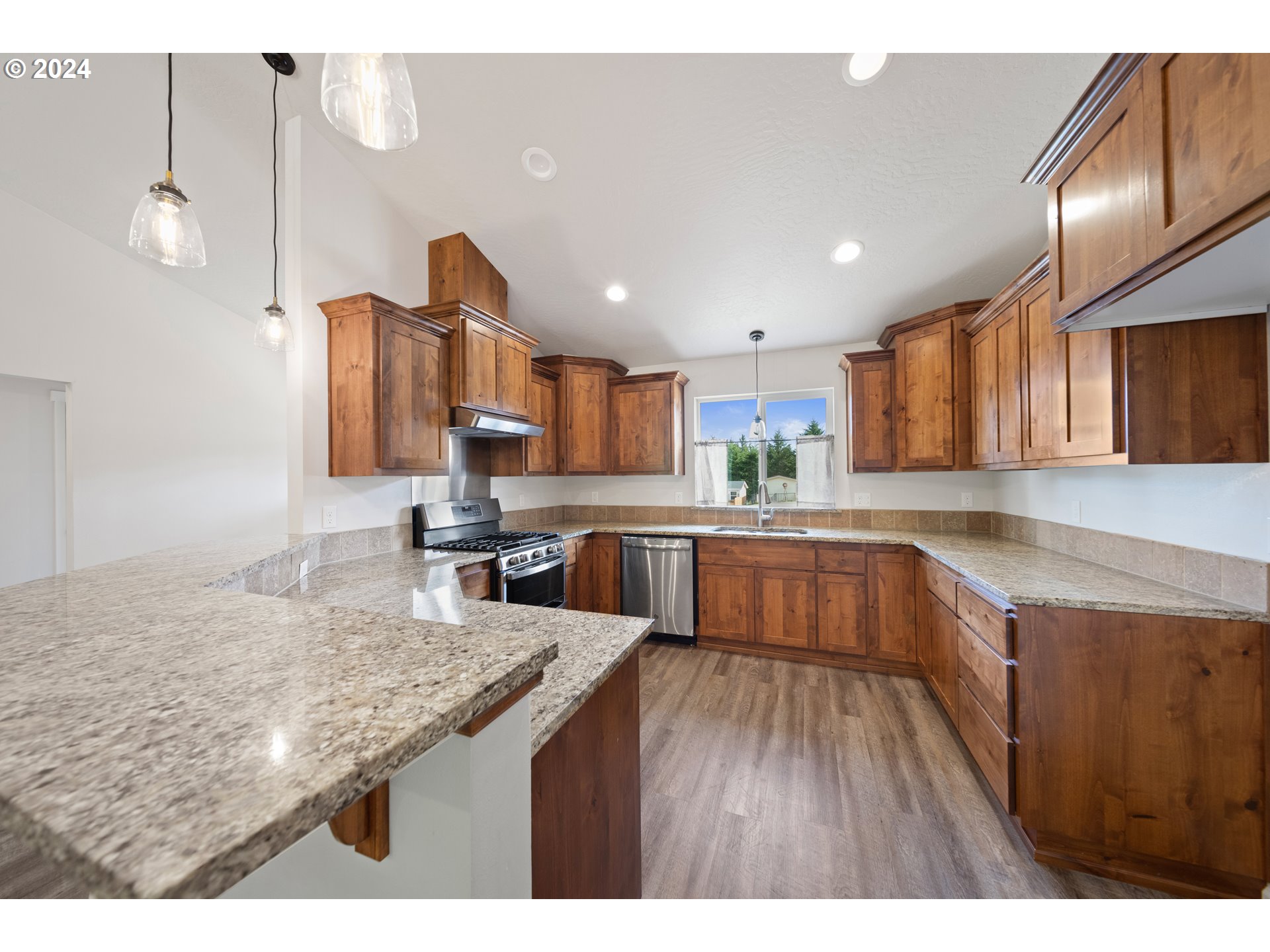 470 Providence Drive Reedsport, OR 97467 - Photo 10 of 41 a kitchen with large counter space and wooden floor