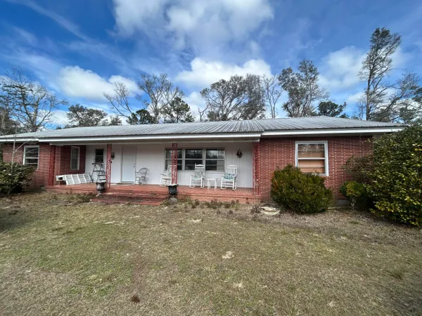 a front view of house with outdoor seating and barbeque oven